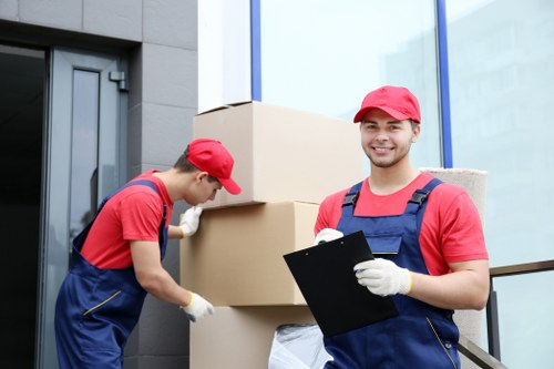 Specialist movers preparing a piano for transport in a local home